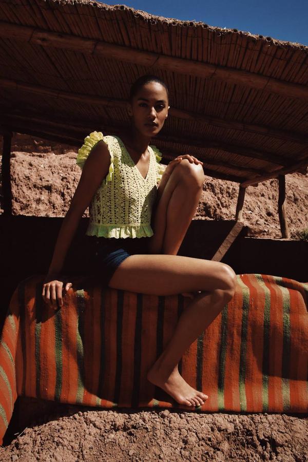 Cuerpo elaborado en tejido de crochet con motivos florales, color verde pistacho claro. Tiene silueta recta, escote de pico, manga sisa y rematan pequeños volantes con detalles bordados y perforados, en mangas y bajo. También está disponible en las tallas S, M y L por 19,95 euros.