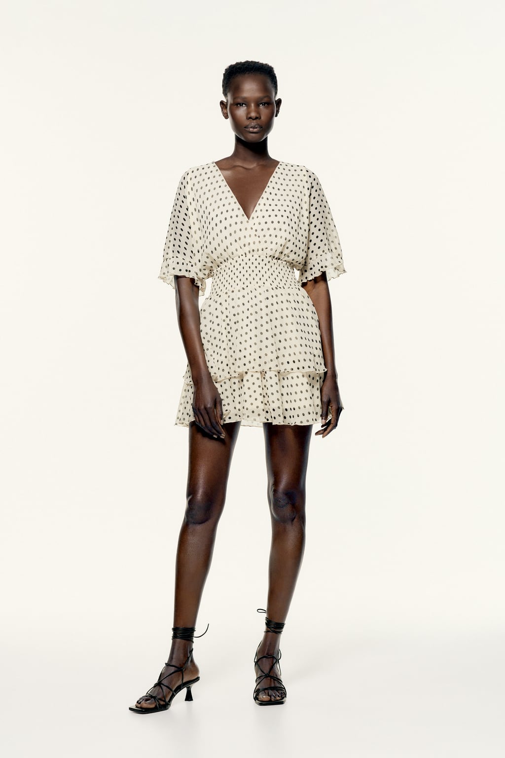 Si hay una combinación de colores que siempre funciona, cuando hablamos de estampado de lunares, esa es el blanco y negro. Llévalos sobre un vestido corto con volantes. Mini vestido de Zara (29,99 euros). 