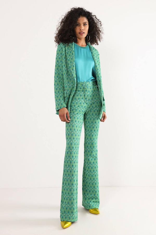 Traje de Dixie decorado con estampado de plumas pavo real en tonos verdes. La parte de arriba es una blazer acomodada a la silueta con cuello solapa y cierre de botón a 171 euros. La prenda inferior, un pantalón de talle alto con bajo acabado en evasé, por 121 euros.