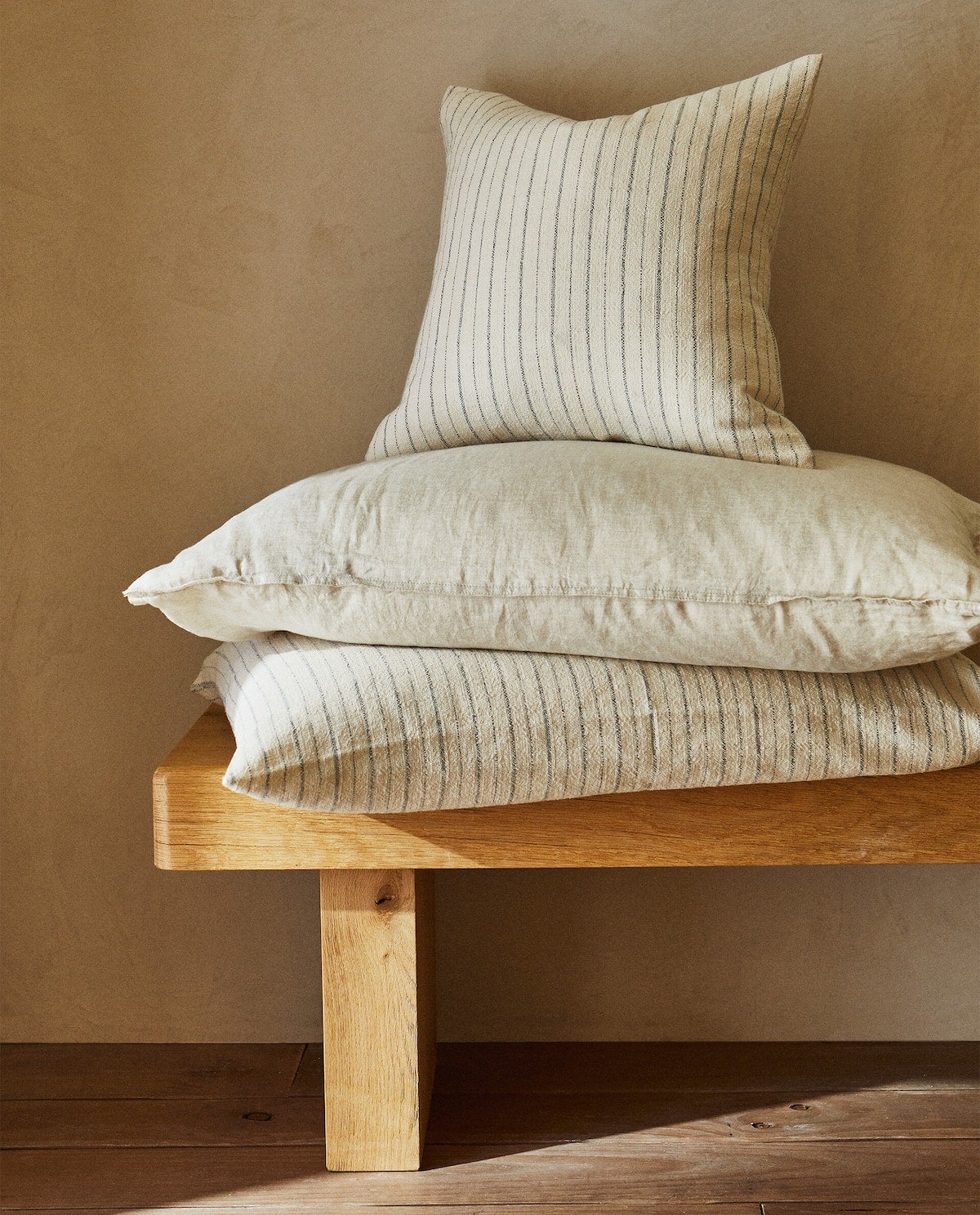 El estampado de rayas y el color azul son los protagonistas de las piezas de estilo mediterráneo de Zara Home. Estos cojines cuestan 19.99 euros. 