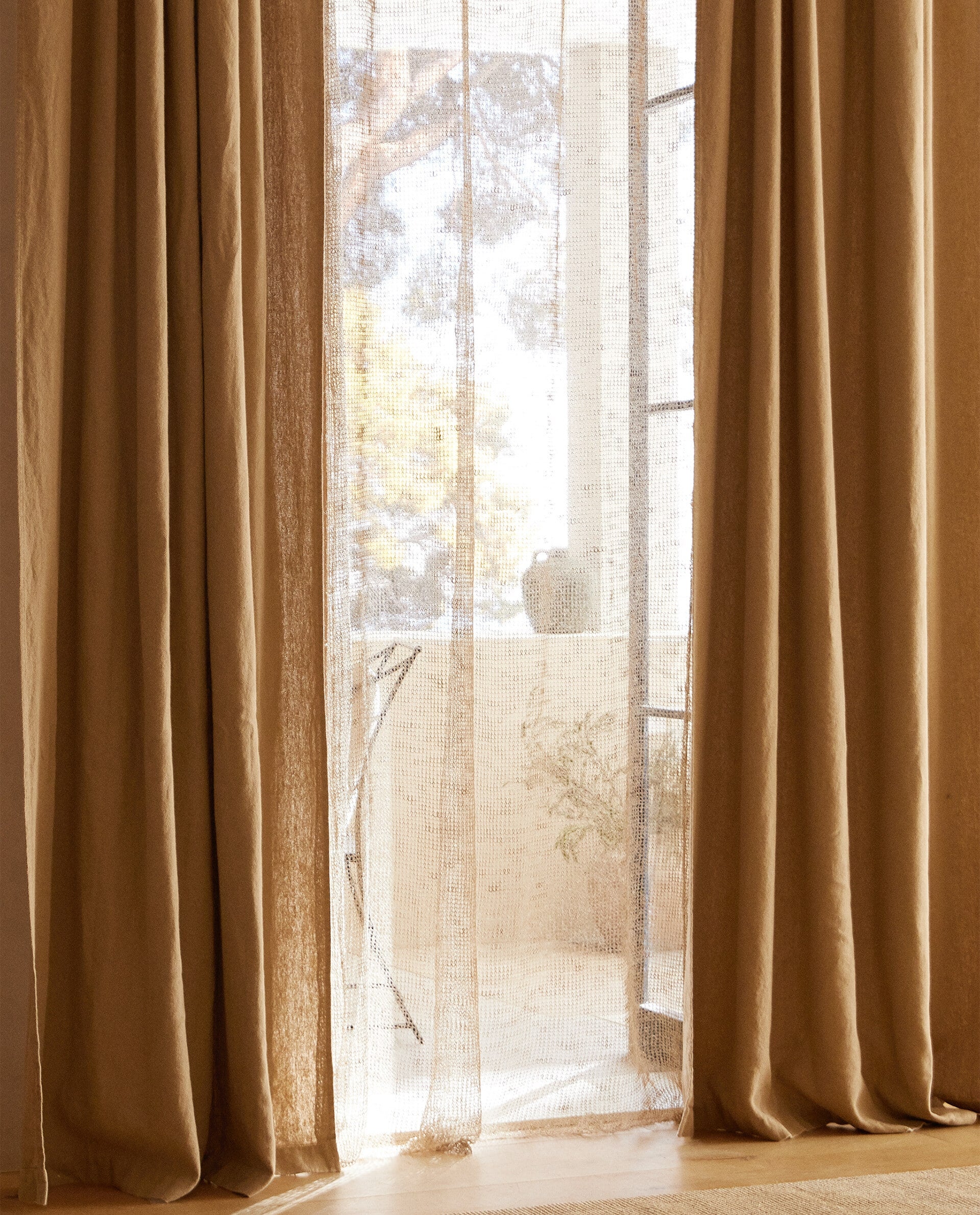 Estas cortinas de punto de lino en color natural te dejarán sentir la brisa y la luz mediterránea en tu salón o dormitorio. Cuestan 49.99 euros en Zara Home. 