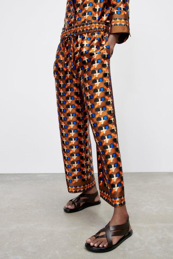 Diseño pijamero para este pantalón en tonos marrones, naranjas y azules que viene con cintura elástica ajustable con cordones y perneras amplias que es de Zara y cuesta 39,95 euros. 