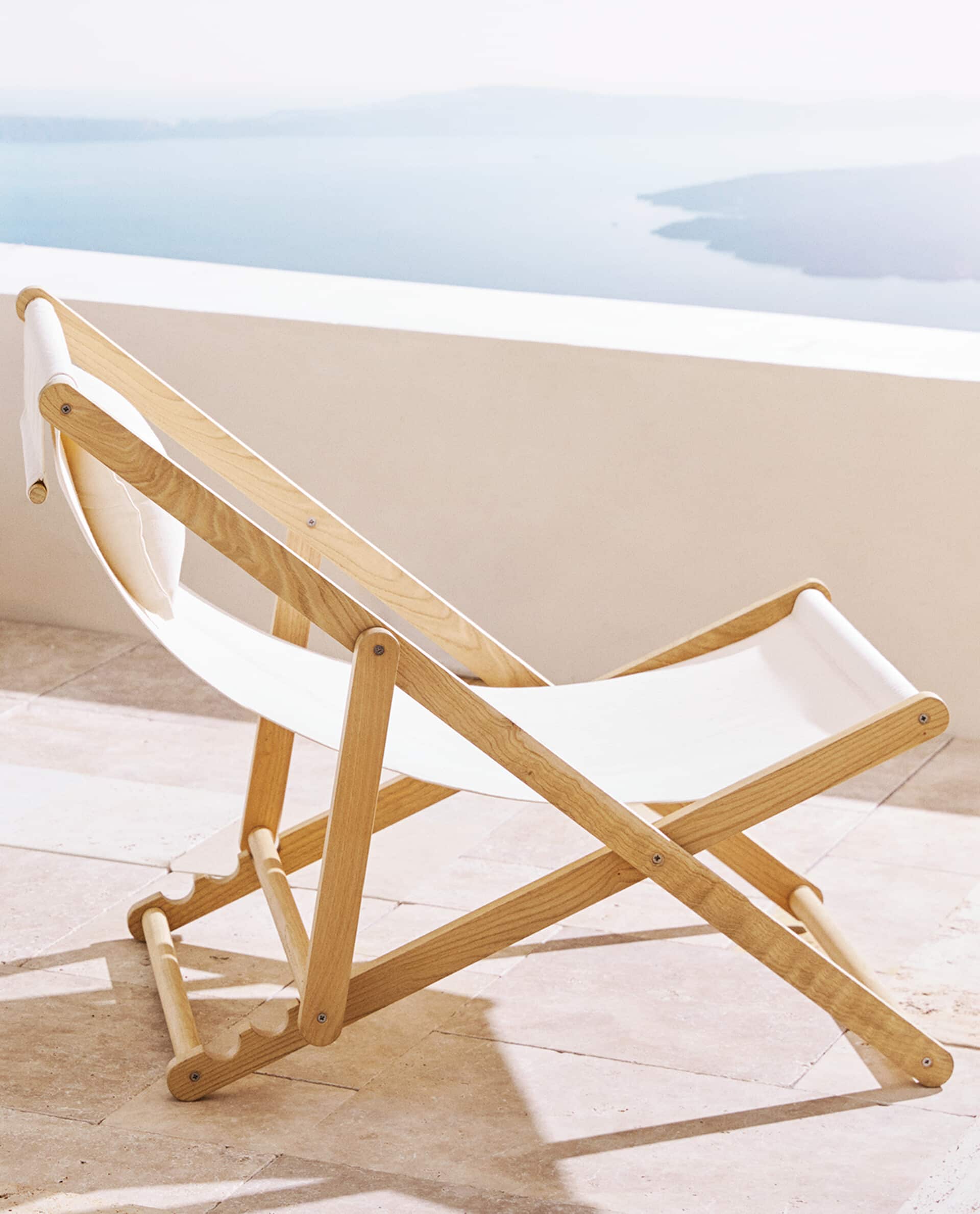 Soñamos con las siestas al aire libre en esta tumbona de madera y algodón orgánico de Zara Home (129 euros).