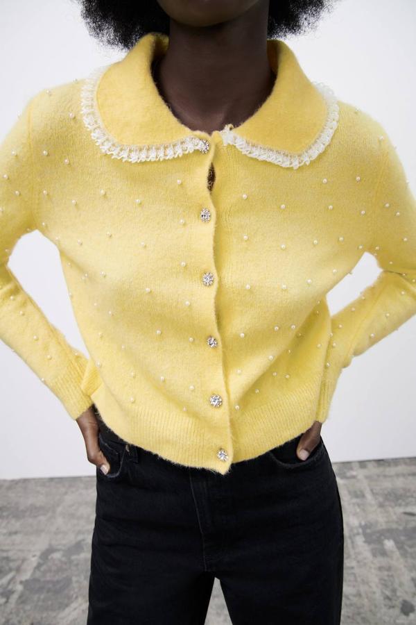 Chaqueta de punto con tacto soft, cuello bobo decorado con encaje, aplicación de perlas y botones joya, en amarillo pastel, de Zara. Está disponible a 29,95 euros.