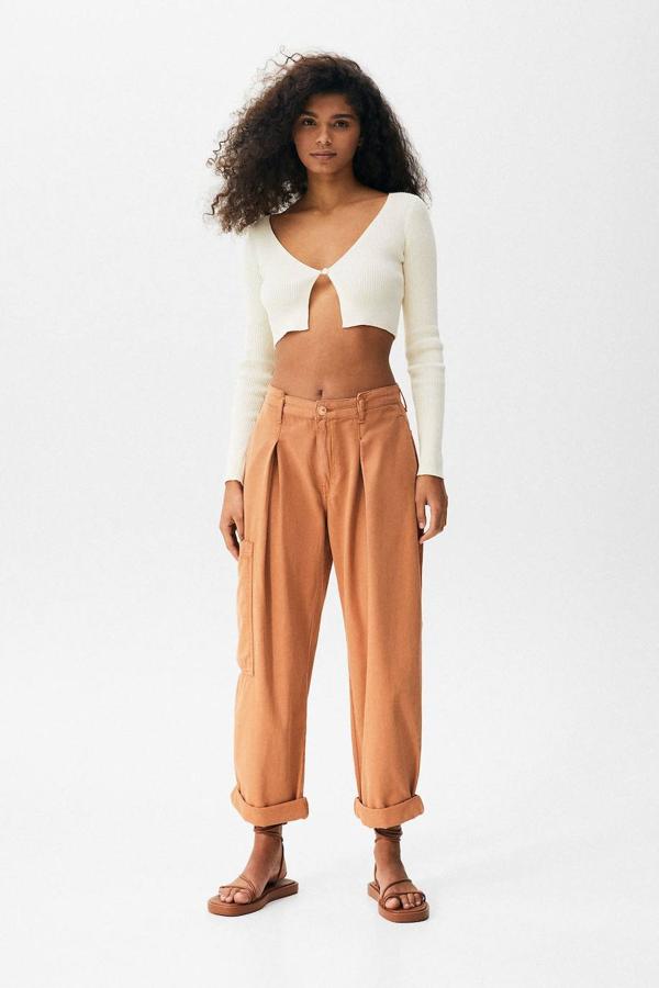 Pantalón cargo de vestir con detalle de pinzas, pernera recta y amplia, bolsillo lateral y traseros, de Pull&Bear. Lo puedes encontrar en tono maquillaje o crudo, a 35,99 euros.