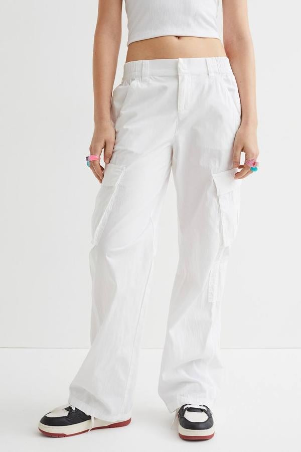 Pantalón cargo de tela, con elástico revestido en la cintura, pernera recta y ancha, bolsillos al bies dos bolsillos con solapa en los laterales, de H&M. Están disponibles en blanco, negro, beige y caqui por 19,99 euros.