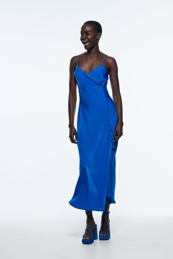 Vestido midi con escote en pico cruzado y tirantes finos. Detalle de falsos botones forrados a tono y bajo con abertura frontal. Color azul cobalto. Precio: 25,95 euros.