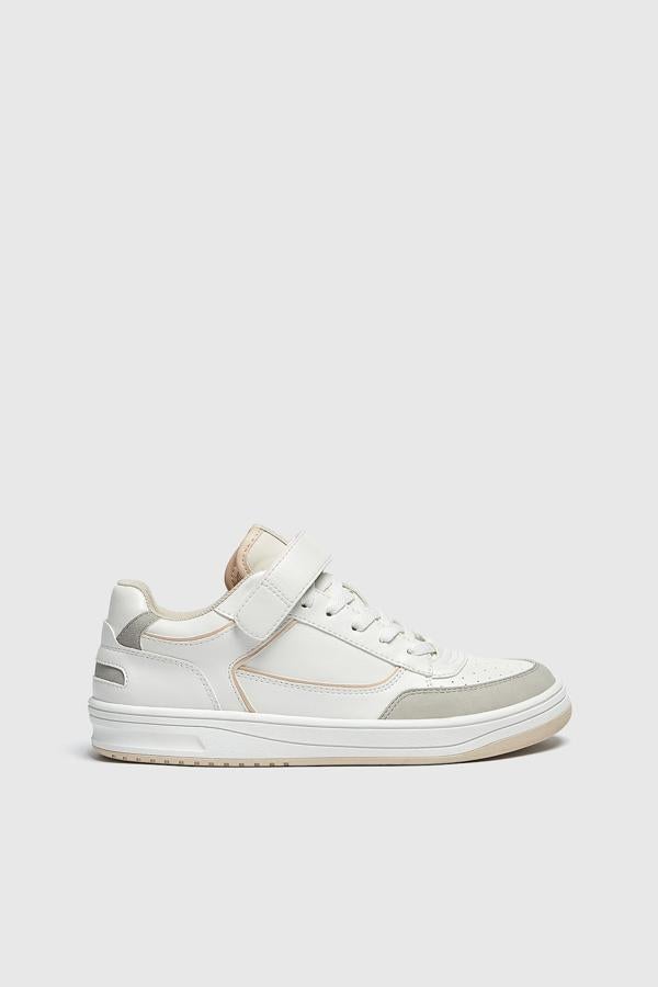 Pull&Bear nos trae una zapatilla blanca que combina los cordones con la típica tira adhesiva. Además de una fusión de diferentes tonos de blancos y grises. Pueden ser tuyas por el precio de 25,99 €.