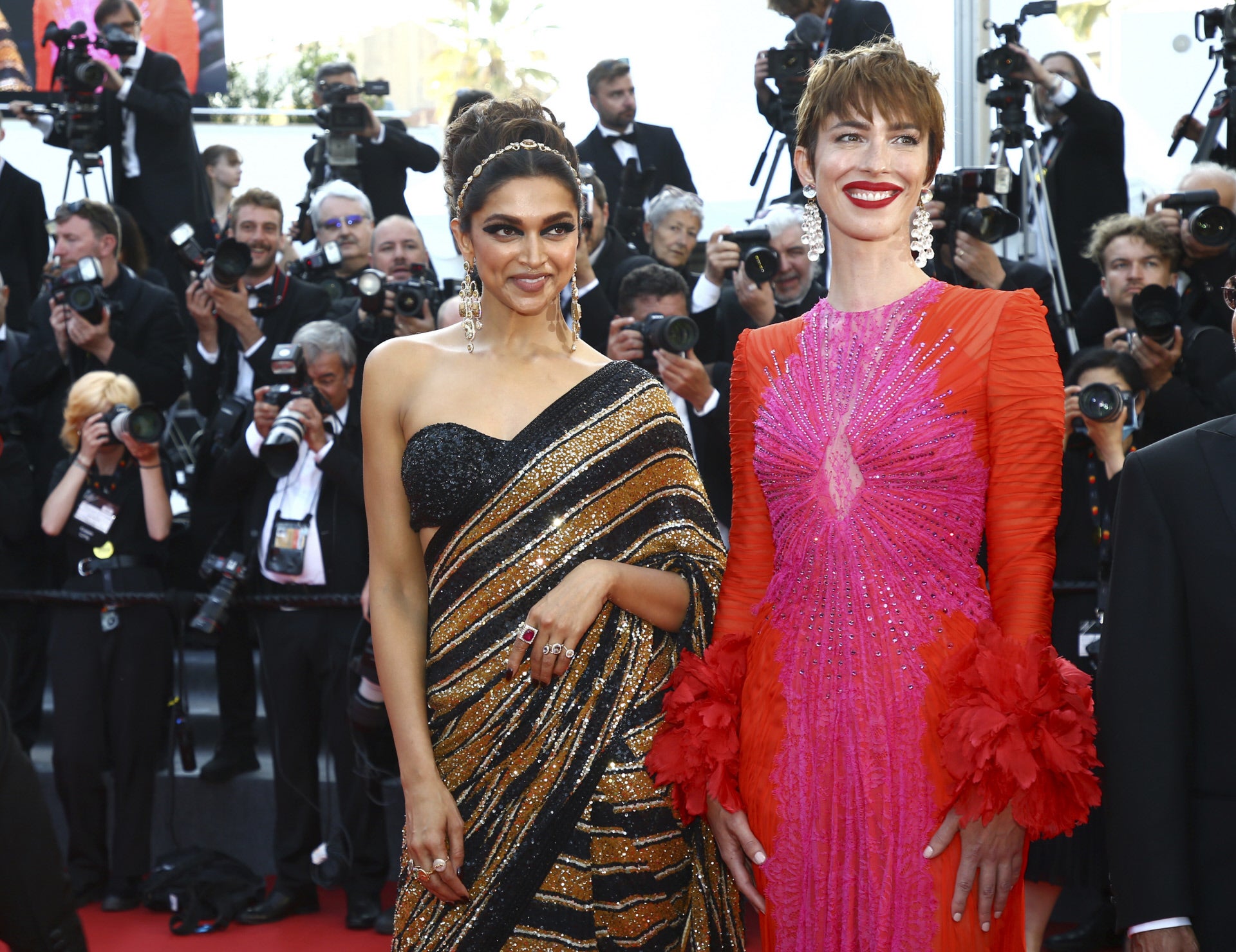 Rebecca Hall es, sin duda, una de nuestras favoritas gracias a este espectacular diseño de Gucci que demuestra que el más es más y confirma que el rojo y el rosa sí son una combinación ganadora. A su lado, Deepika Padulone, de Sabyasachi.