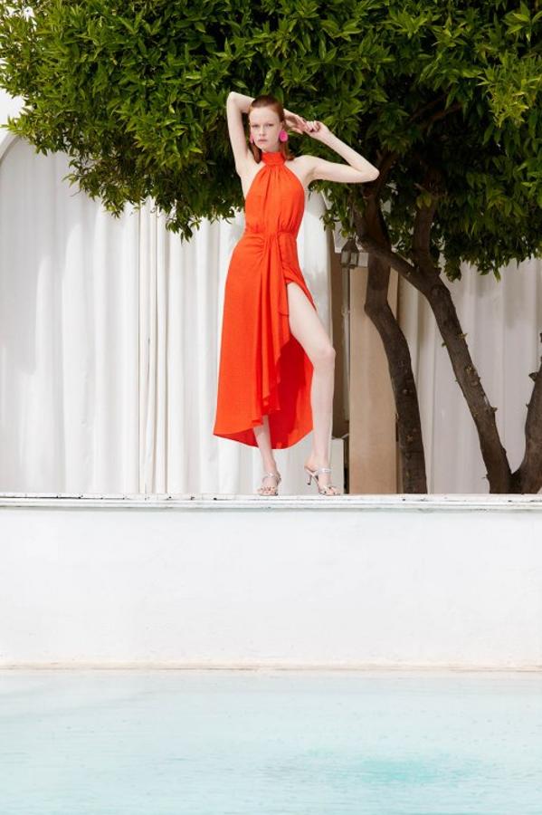 Vestido jaquard con cuello halter y abertura delantera en color naranja oscuro. Precio: 49,99 euros.