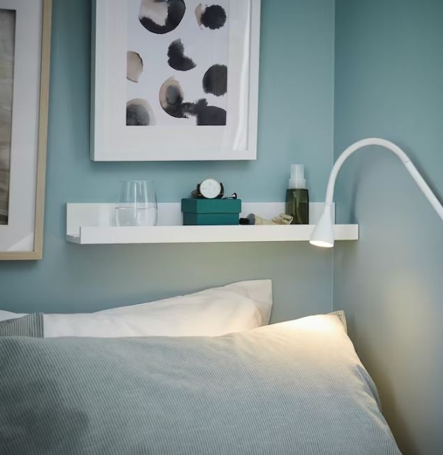 Si la solución de la tabla de cortar a modo de mesilla te pareció brillante, fíjate en esta idea perfecta para dormitorios pequeños: un simple estante para cuadros como el modelo MOSSLANDA (6 euros) puede ser la alternativa perfecta, porque no ocupa espacio y te permite tener a mano todo lo que necesites. 