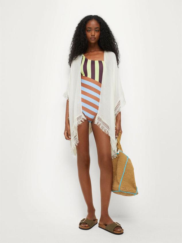 Kimono estilo boho con flecos en los bordes y disponible en tres colores: blanco, negro y verde. Ideal para tus looks playeros. Precio: 19.99 euros.