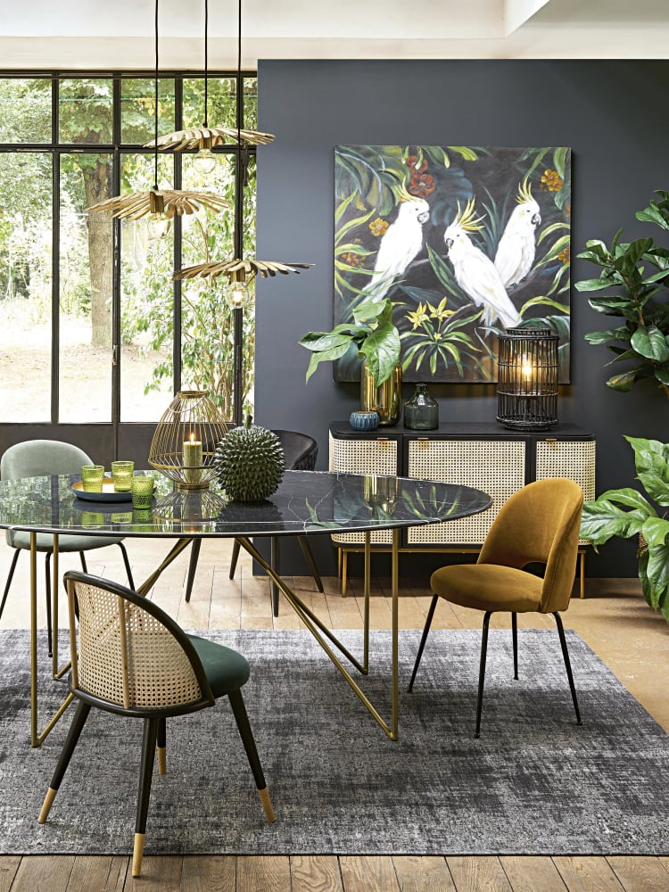 Virgina Gasch nos propone "utilizar colores verdes, el verde es el color de la naturaleza y siempre es un gran complemento en la decoración. Inspira calma, serenidad y armonía, pero, además, tiene un efecto revitalizante en nuestro estado de ánimo, como un maravilloso día al aire libre. Utilizar plantas llenará tu casa de vitalidad y alegría. Atrévete a colocarlas de forma original y divertida y a elegir aquellas que te transporten a lugares que te hagan soñar". En la foto, un ambiente creado por Maisons du Monde: la mesa cuesta 1.299 euros, las lámparas 189 euros, el aparador de ratán 799 euros y las sillas de inspiración vintage, 109 euros.