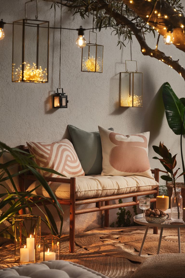 La madera y las fibras naturales son las protagonistas de este espacio exterior de H&M Home. La mesa baja de centro cuesta 19.99 euros, los cojines están disponibles desde 7.99 y los preciosos faroles que aportan una cálida luz indirecta, 12.99 euros.