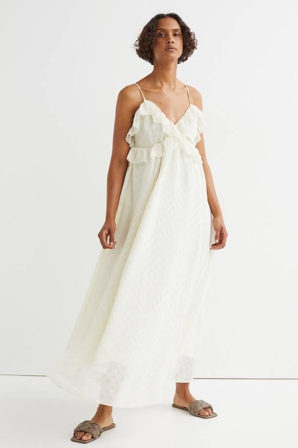 Vestido midi confeccionado en tejido de crepé con lunares a tono, tirantes finos, falda amplia con vuelo y adorno de volantes en el pecho, de H&M. Lo encontrarás a 39,99 euros.