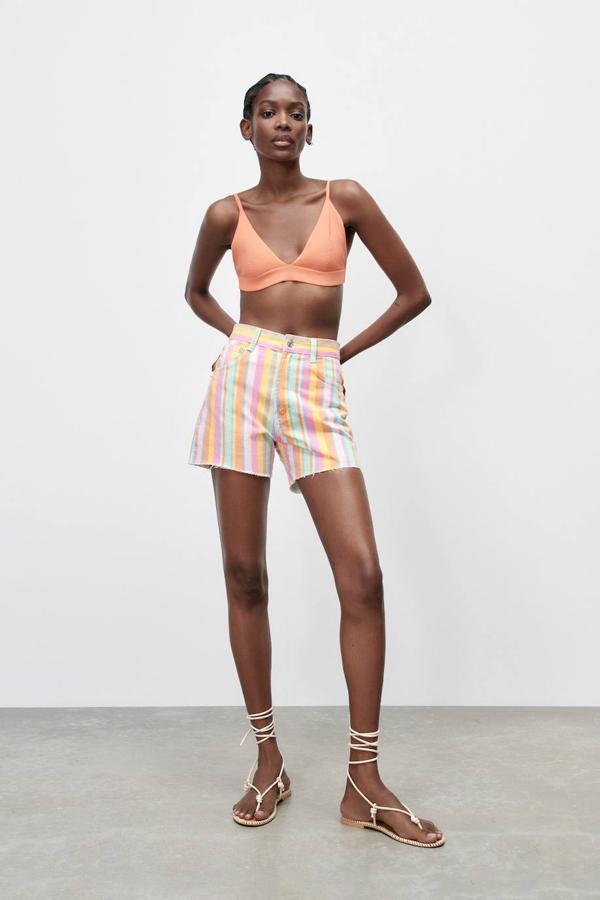 Shorts en tejido denim con estampado a rayas multicolor, tiro alto, cinco bolsillos, trabillas para el cinturón y bajo desflecado, de Zara. Los encontrarás por 22,95 euros.