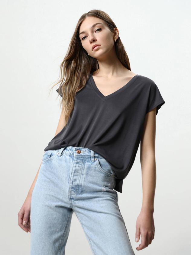 Camiseta fluida y ligera con escote de pico, silueta relajada y manga corta. Puedes comprarla gris oscuro, malva claro, verde o natural, por 7,99 euros.