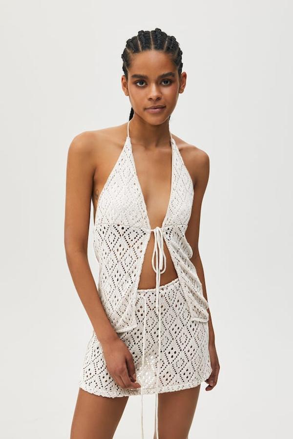 Minifalda en tejido crochet y cintura ajustable con cordón de color blanco. Precio: 19,99 euros.