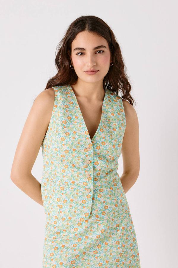 Chaleco de sastre con estampado floral en tonos naranja, azul y verde, escote de pico, bolsillos de ojal y cierre frontal de botones. Su precio es de 59,99 euros.