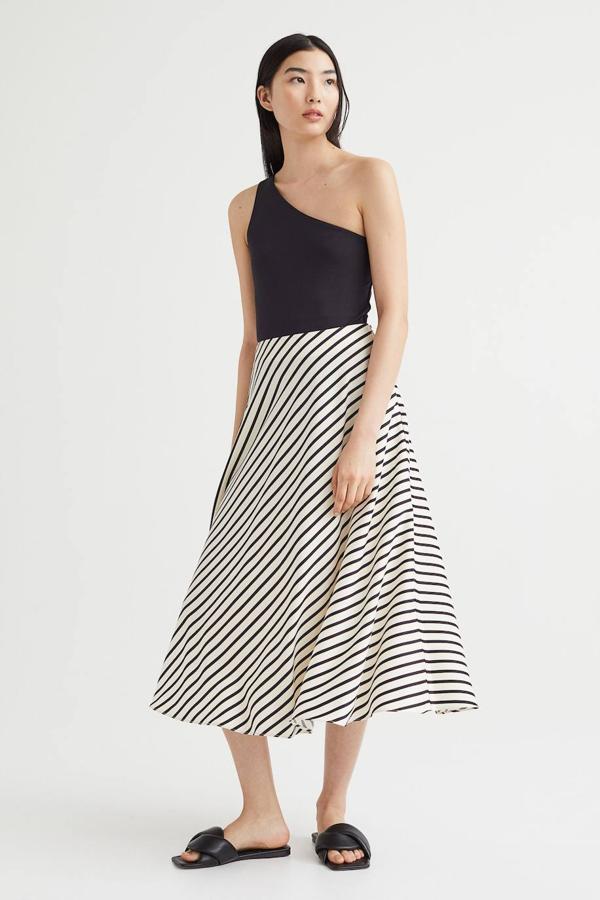 Falda midi en tejido de satén con talle alto, corte evasé y suave caído con vuelo, en estampado a rayas blanco y negro, de H&M. Cómprala a 34,99 euros.