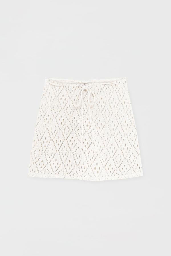 Minifalda en tejido crochet con transparencias. Idóneo para mujeres atrevidas, pero también tras un día de sol y en playa en bikini. Puedes ajustar la cintura con un cordón para marcar tu cintura. Es de Pull&Bear. Precio: 19,99 €. 