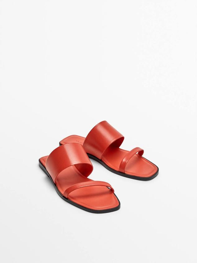 Sandalia plana destalonada confeccionada en piel con dos tiras en diferentes anchos, color coral, de Massimo Dutti. Su precio es de 69,95 euros.