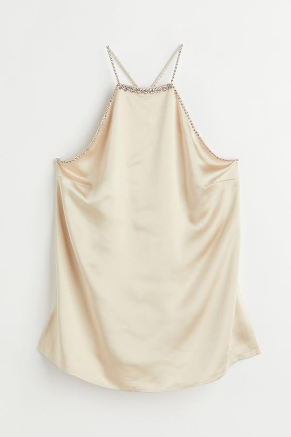 Este top joya evasé de H&M es de satén con escote alto y ribeteado en strass. Sus tirantes espagueti siguen la misma línea y son cruzados en la espalda. Precio: 39,99 €. 