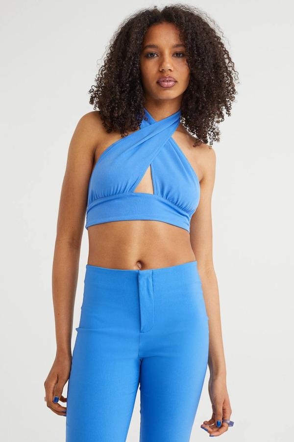 Top crop con escote halter cruzado, abertura frontal y tiras para anudas en la nuca y la espalda, de H&M. Lo puedes comprar en azul, verde, blanco y negro, por 9,99 euros.