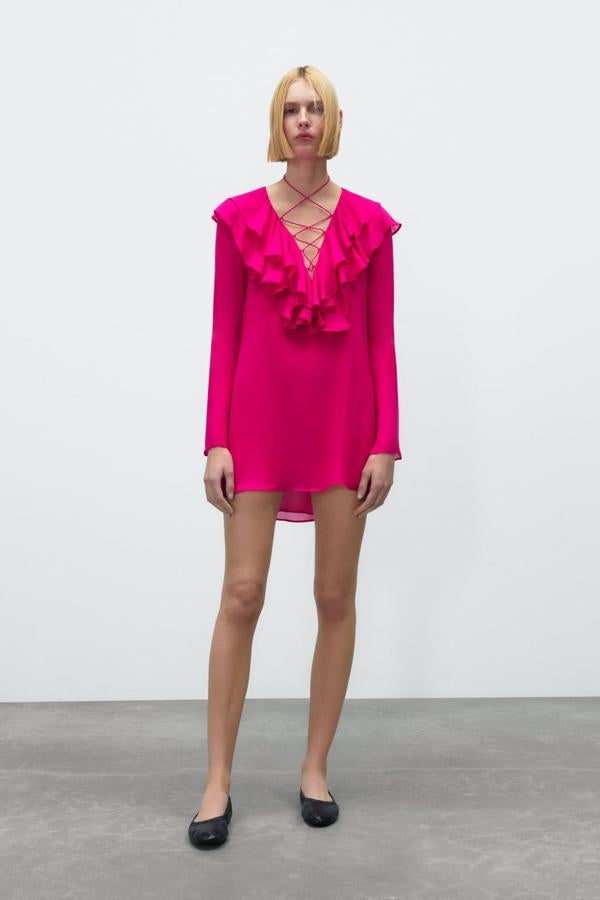 Este es uno de los diseños de Zara más buscados de la temporada. ¡Y no nos estraña nada! De manga larga, en tamaño mini y cubierto de volantes de color fucsia en el pecho. Mini vestido de Zara (35,99 euros)