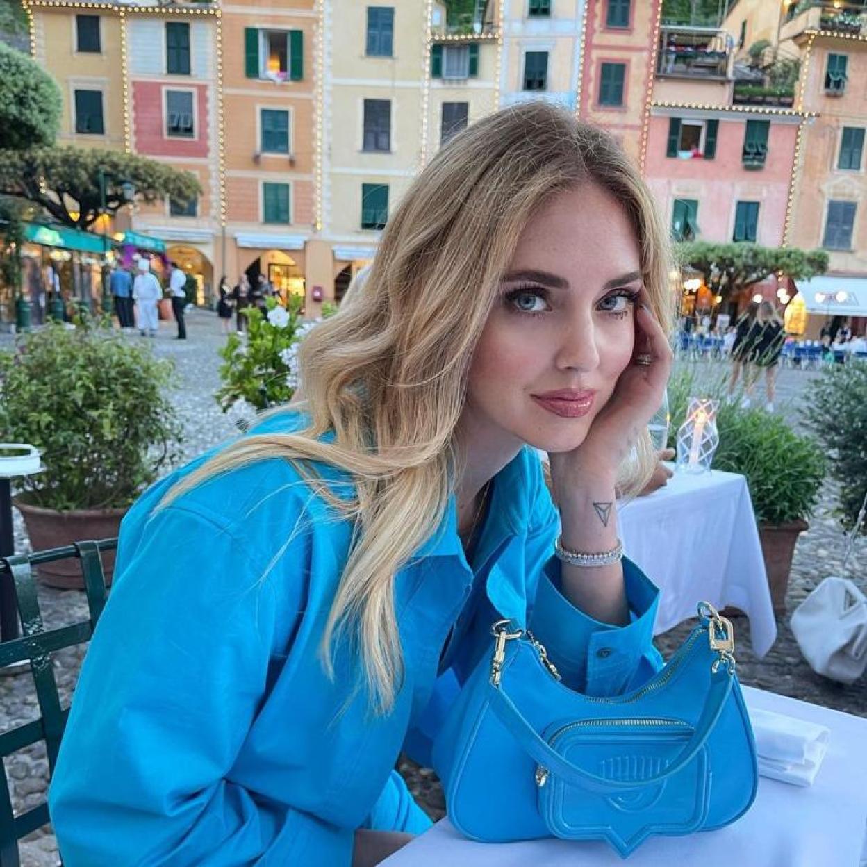 chiara Ferragni vestida de azul apoyando su cara sobre una mano