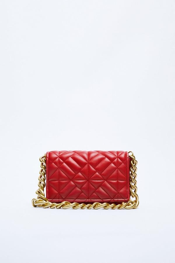 El clásico bolso acolchado, inspirado en el 2.55 de Chanel, repite temporada tras temporada en Zara. El color rojo es uno de lo más bonitos. Bolso con cadena dorada de Zara (22,99 euros)