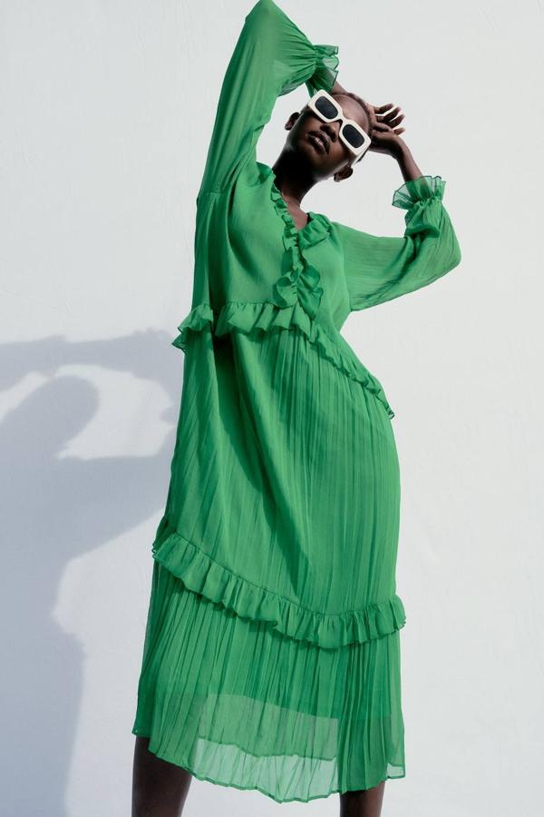 Vestido verde en tejido vaporoso semitransparente efecto arrugado, con manga larga abombada, escote de pico, silueta relajada, falda con vuelo y detalles de volantes, de Zara. Lo encontrarás por 39,95 euros.