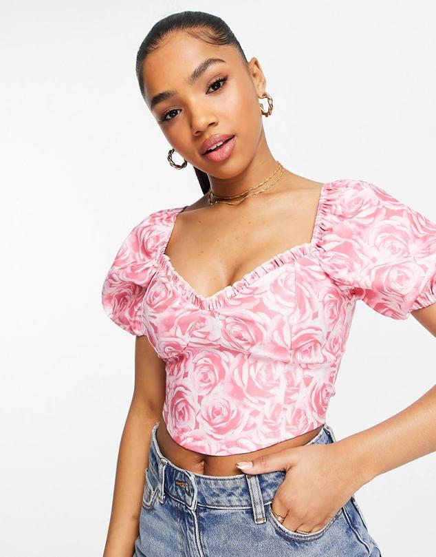 Top rosa estilo corsé con mangas abullonadas de bengalina. Cuenta con un estampado floral en tonos rosados. Es de ASOS. Precio: 32,99 €. 