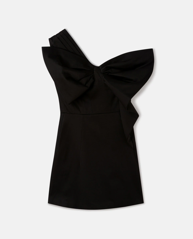 Vestido corto en negro con lazo en el hombro. Deja al descubierto toda la zona de las clavículas y cuello, siendo un toque bastante sofisticado. Es de El Corte Inglés. Precio: 69,99 €.