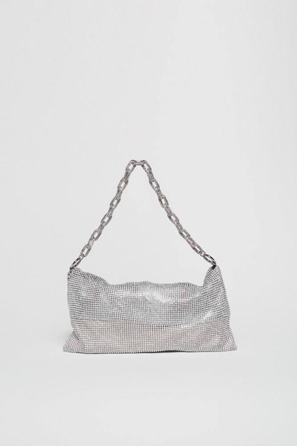 Bolso tamaño mediano confeccionado en maña metálica de strass y cadena de hombro, en plateado o dorado, de Sfera. Cuesta 35,99 euros.