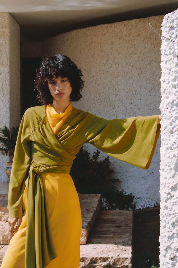 Blusa en tejido ligero y satinado con escote de pico, manga larga amplia y cierre mediante lazada multiposición, color oliva, de Zara. Cuesta 29,95 euros.