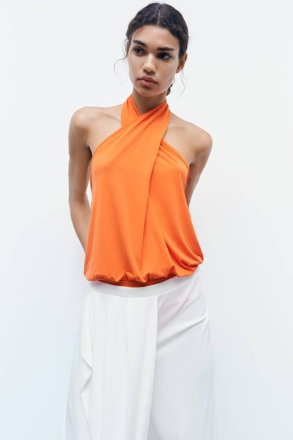 Body naranja con silueta relajada, escote cruzado halter y cierre de botones al cuello. Cuesta 19,95 euros.