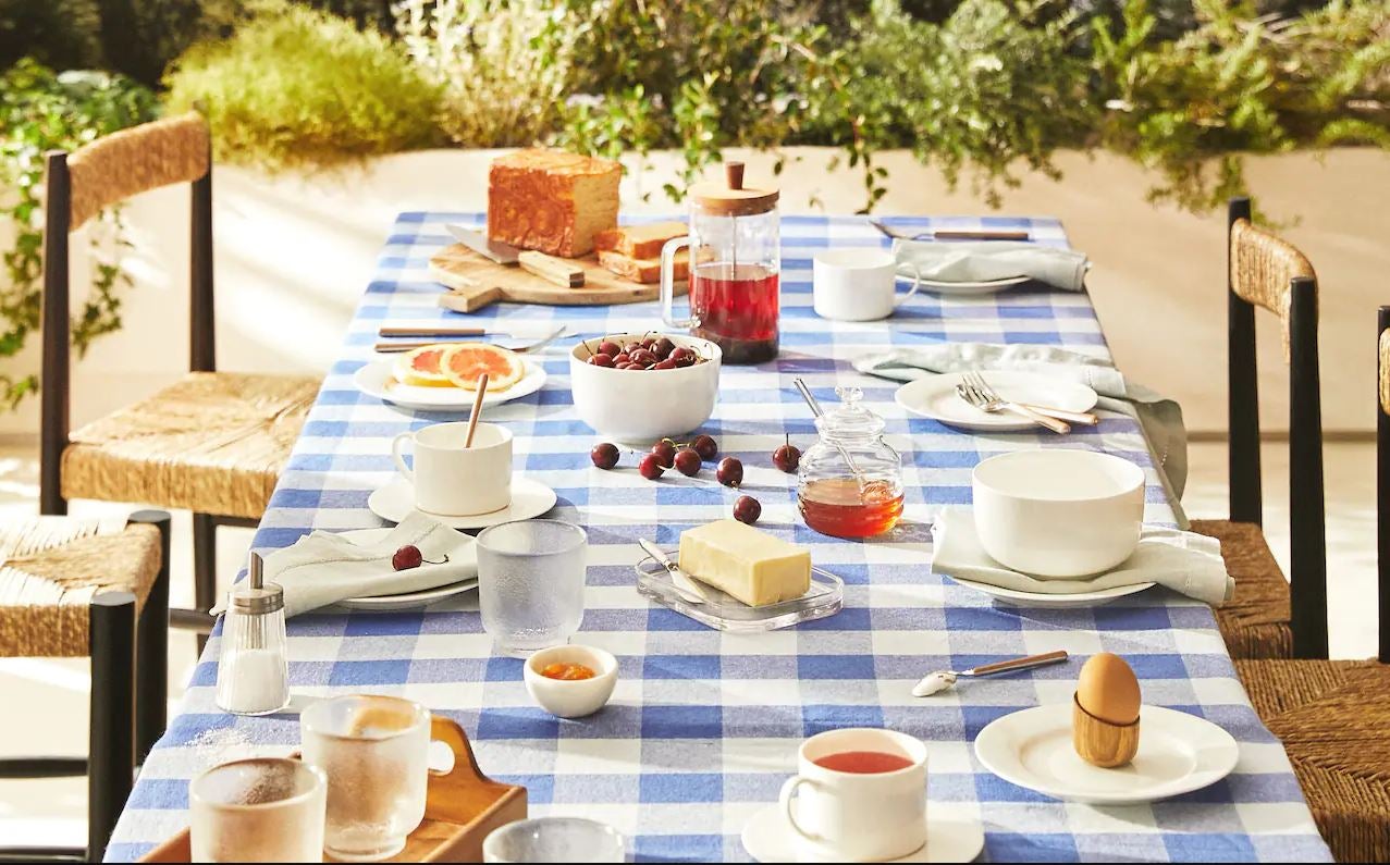 Seguimos con las mesas de verano, y nada mejor que una vajilla de loza blanca sencilla para renovar nuestro fondo de armario del menaje. Esta de Zara Home está disponible, por piezas, antes de las rebajas, desde 3.99 euros. Y el mantel con estampado de cuadros en azul y blanco cuesta 49.99 euros.