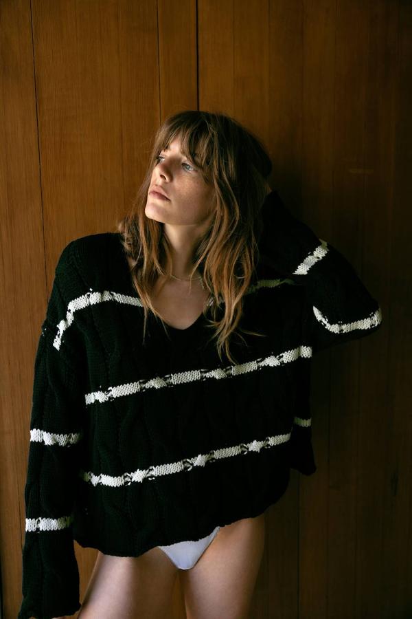 Jersey de punto con patrón de ochos y relieve, escote amplio de pico, manga larga, terminaciones sin rematar y estampado a rayas finas, negro y blanco.
