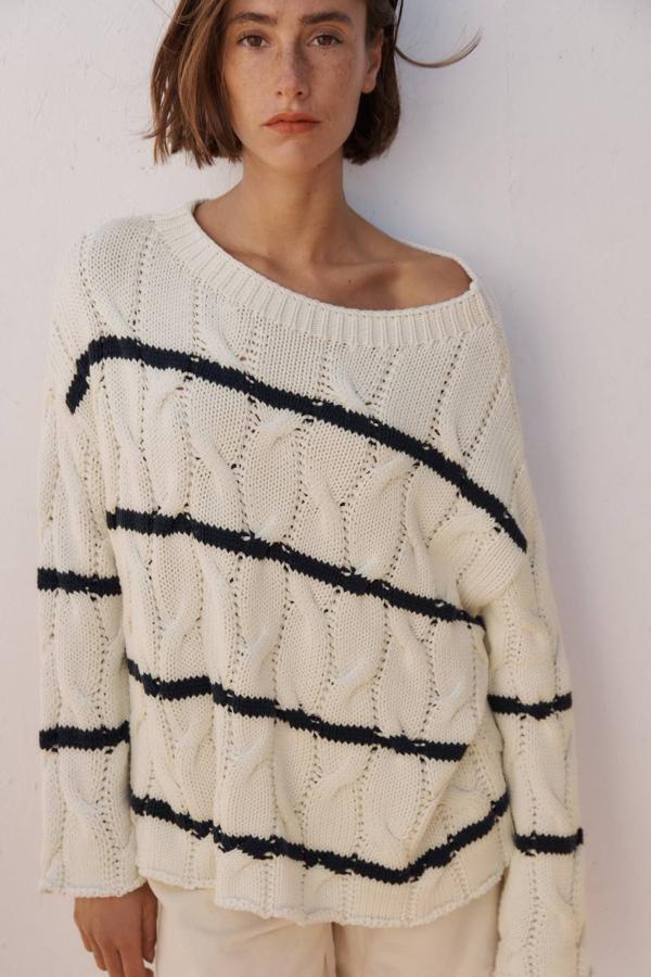Jersey de punto amplio con patrón a ochos y rayas finas en crudo y negro, con cuello redondo, silueta relajada y manga larga.