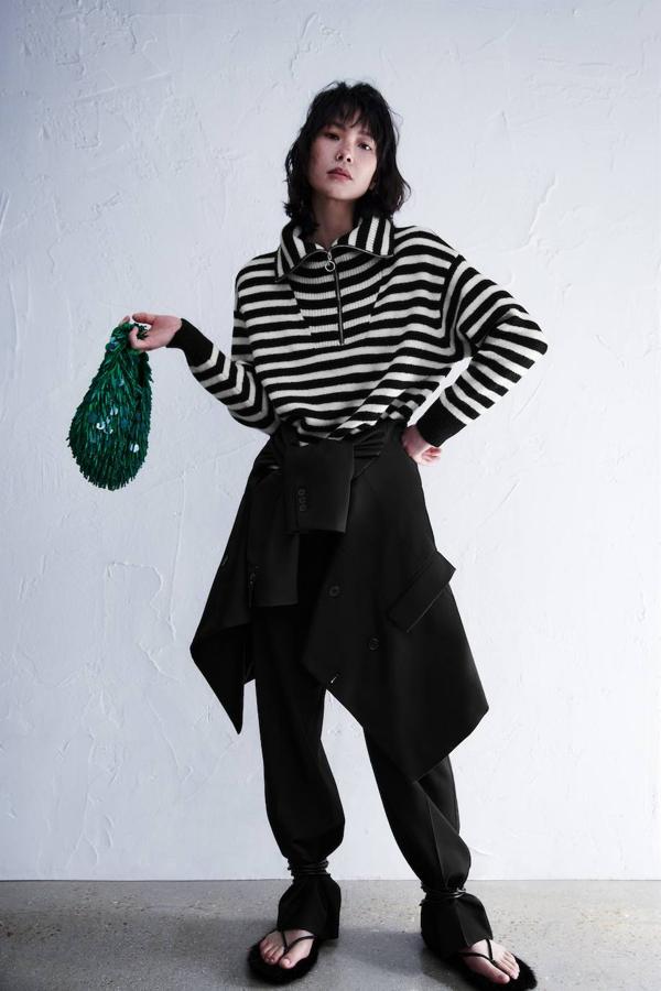 Jersey de punto holgado con print a rayas en negro y blanco, cuello subido multiposición con cierre de cremallera, manga larga y acabados en rib.