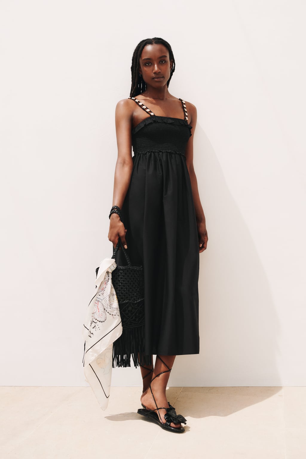 El negro también es para el verano. Elige un vestido sencillo con pequeños detalles en los tirantes. Vestido midi de Zara (29,99 euros)