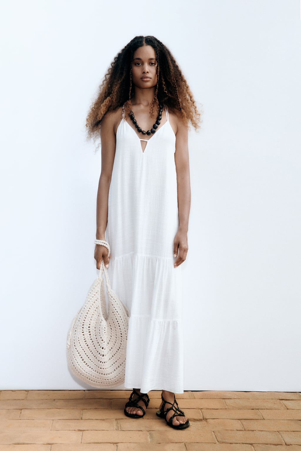 Di hay un color que no puede faltar en ningún armario estival ese es el blanco. Favorece como ninguno cuando la piel está ligeramente bronceada. Vestido midi de Zara (34,99 euros)