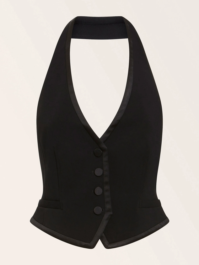 Chaleco tipo esmoquin con escote en V en su versión más sobria por su color negro. Es de Guess. Precio: 160 €.