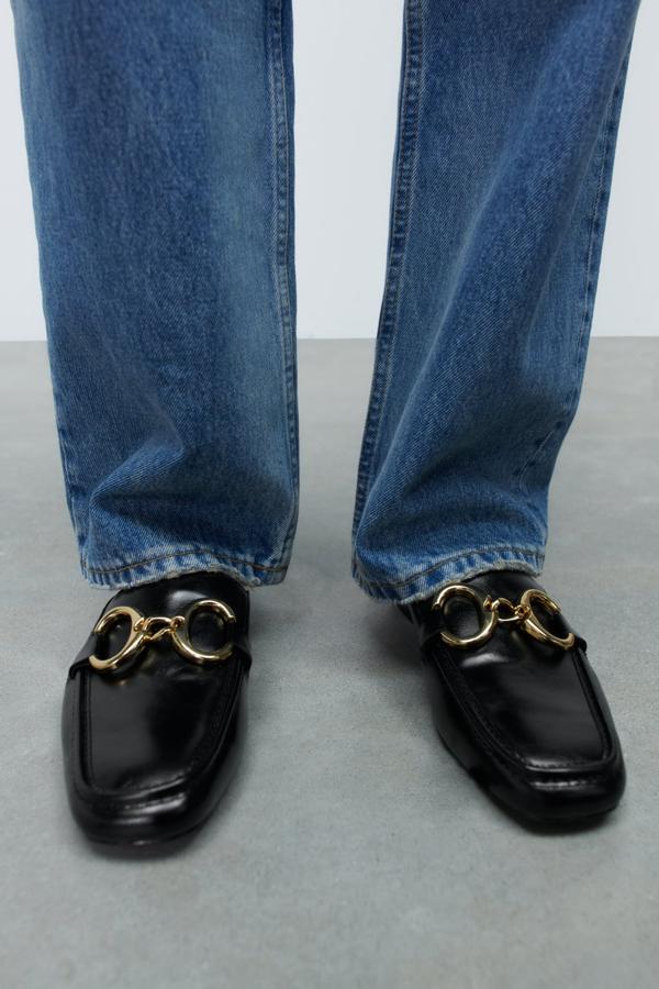 Y no podía faltar en esta selección un buen par de zapatos. Los mocasines destalonados son la compra estrella de cara a los meses venideros. Mocasines negros de Zara (15,99 euros). 