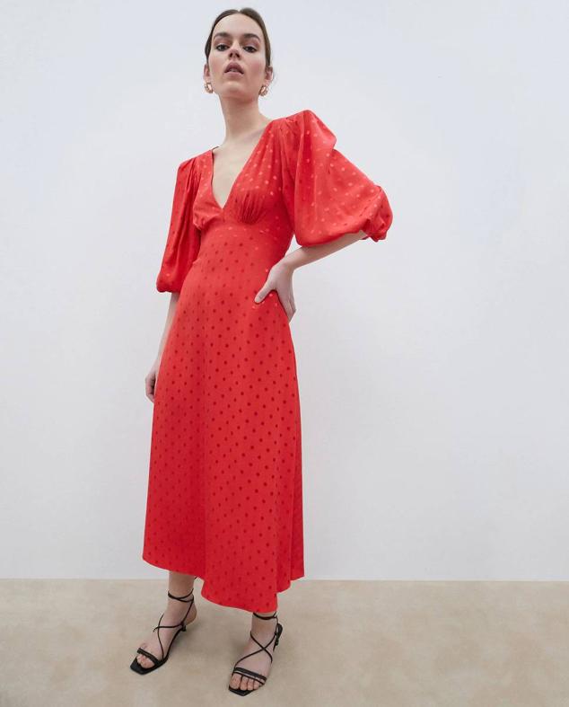 Vestido midi en tejido jacquard con lunares color rojo. Es un diseño de manga corta abullonada, escote de pico frontal y en la espalda, detalles de tiras en la parte trasera y falda con vuelo. Está disponible en El Corte Inglés con un descuento del 50%, a 49,99 euros.