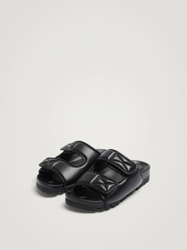 Sandalias planas destalonadas con suela gruesa y dentadas, acabado efecto piel y doble tira con velcro, color negro. Las encontrarás rebajadas a 29,99 euros.