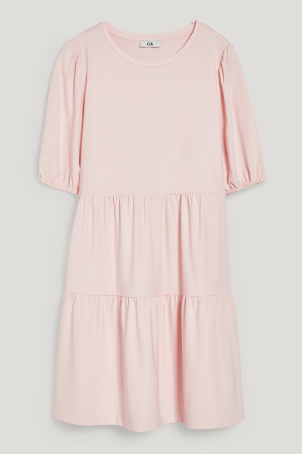 Vestido corto estilo elástico de manga corta. Punto suave y con falda de volantes. El corte debajo del cuerpo alarga la figura ópticamente. Diseño liso. De C&A. Precio rebajado: 17,99 €. 