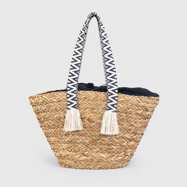 Capazo de fibras trenzadas con forro de tela y asas con bordado étnico y remate de flecos, de El Corte Inglés. Cuesta, con descuento, 23,95 euros. Cómpralo aquí