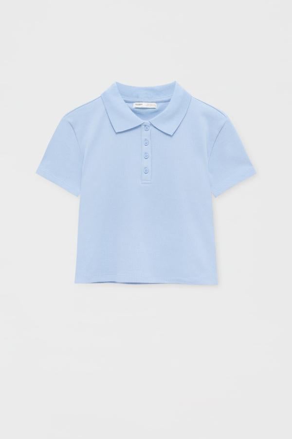 Polo para mujer cropped de manga corta con cierre de botones delanteros. Confeccionado en algodón, es ideal para llevarlo con la zona de la barriga al aire. Es de Pull&Bear. Precio rebajado: 5,99 €.